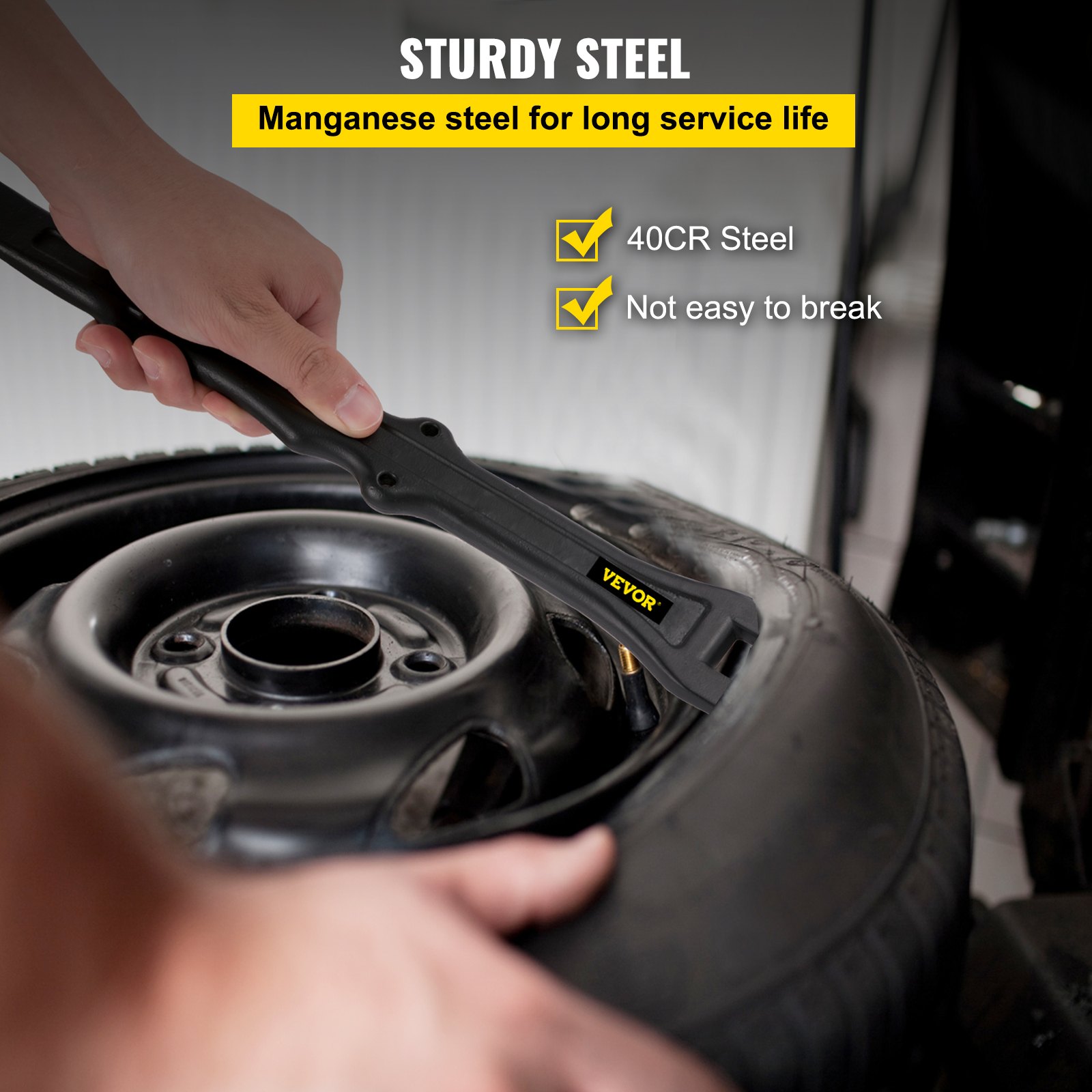 hand using VEVOR tire iron set to remove tire; sturdy manganese steel tool.