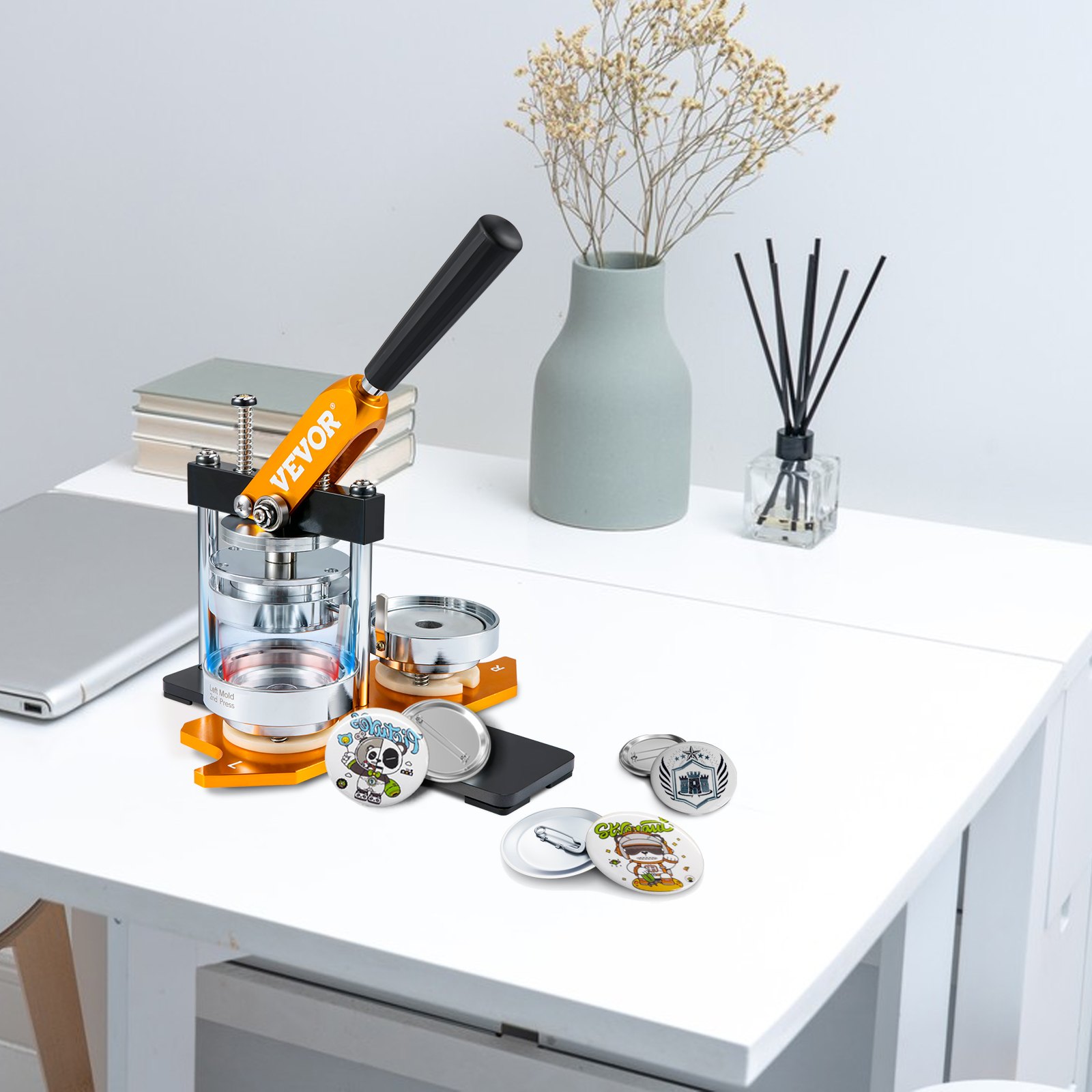 VEVOR button maker on a desk with buttons, laptop, books, and decorative items in the background.