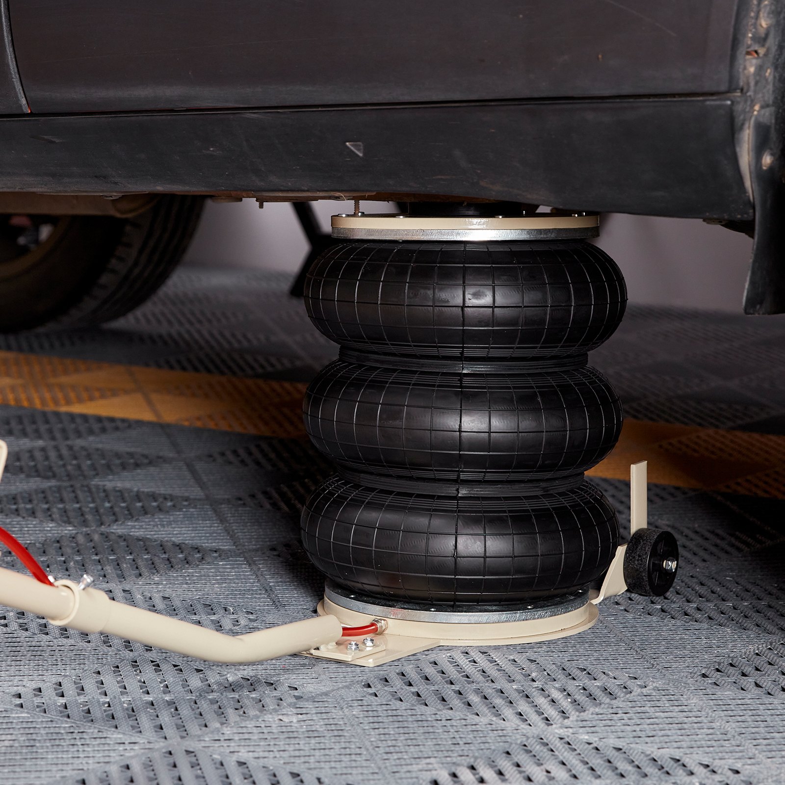car lifted by VEVOR triple bag air jack on garage floor.