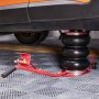 VEVOR air jack lifting an orange car on a patterned floor.