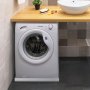 white washing machine under wooden countertop with sink, plant, soap, and VEVOR washing machine pan.