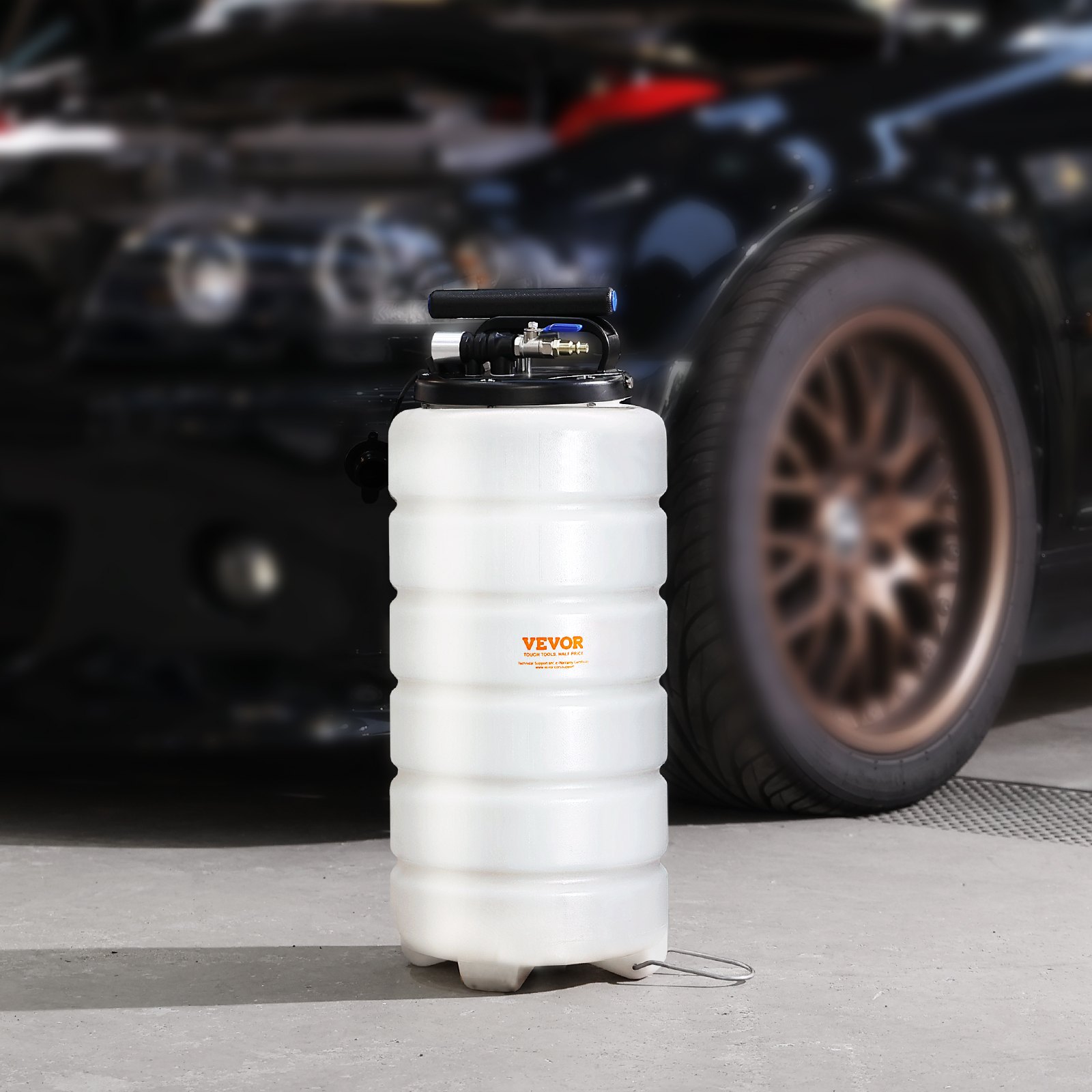 VEVOR fluid extractor in a garage with a parked black car in the background.