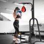 woman training with boxing gloves near VEVOR punching bag stand in a gym setting.