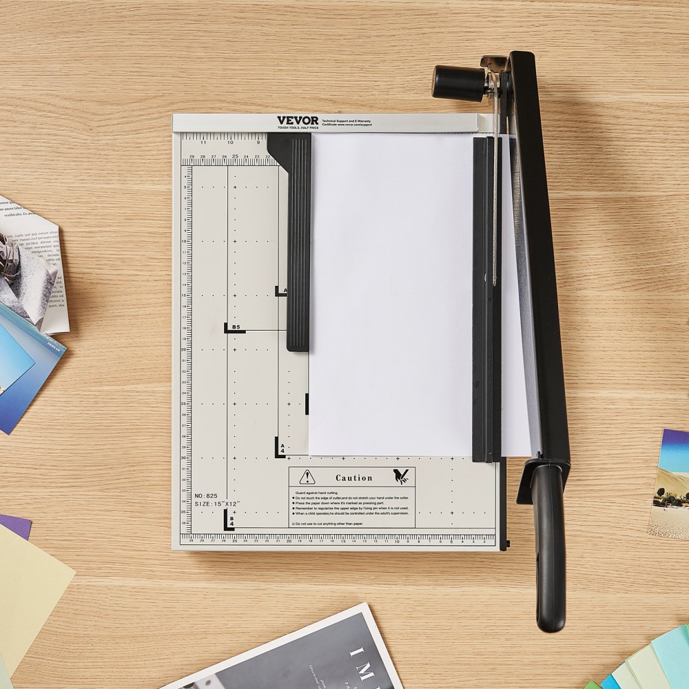 VEVOR paper cutter on a wooden desk with various colorful paper sheets nearby.