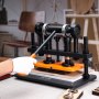 VEVOR leather cutting machine in a workshop, operated by a person wearing a white glove.