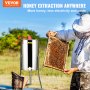 beekeeper using VEVOR honey extractor in a field, showcasing honeycomb frame and bee smoker.