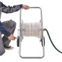 person using VEVOR hose reel cart with coiled hose and green hose attachment.