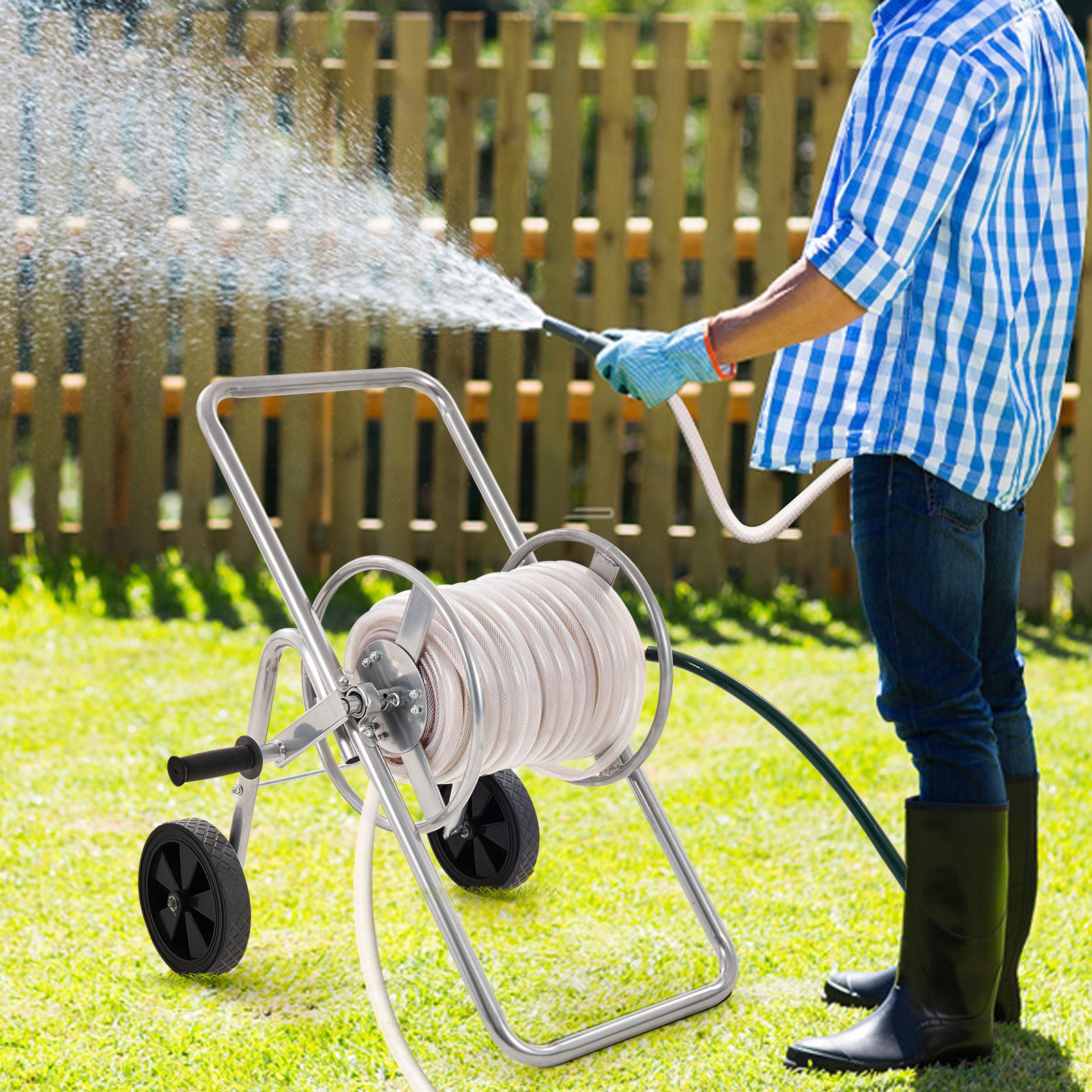 man watering lawn with a VEVOR hose reel cart near a wooden fence in a garden.