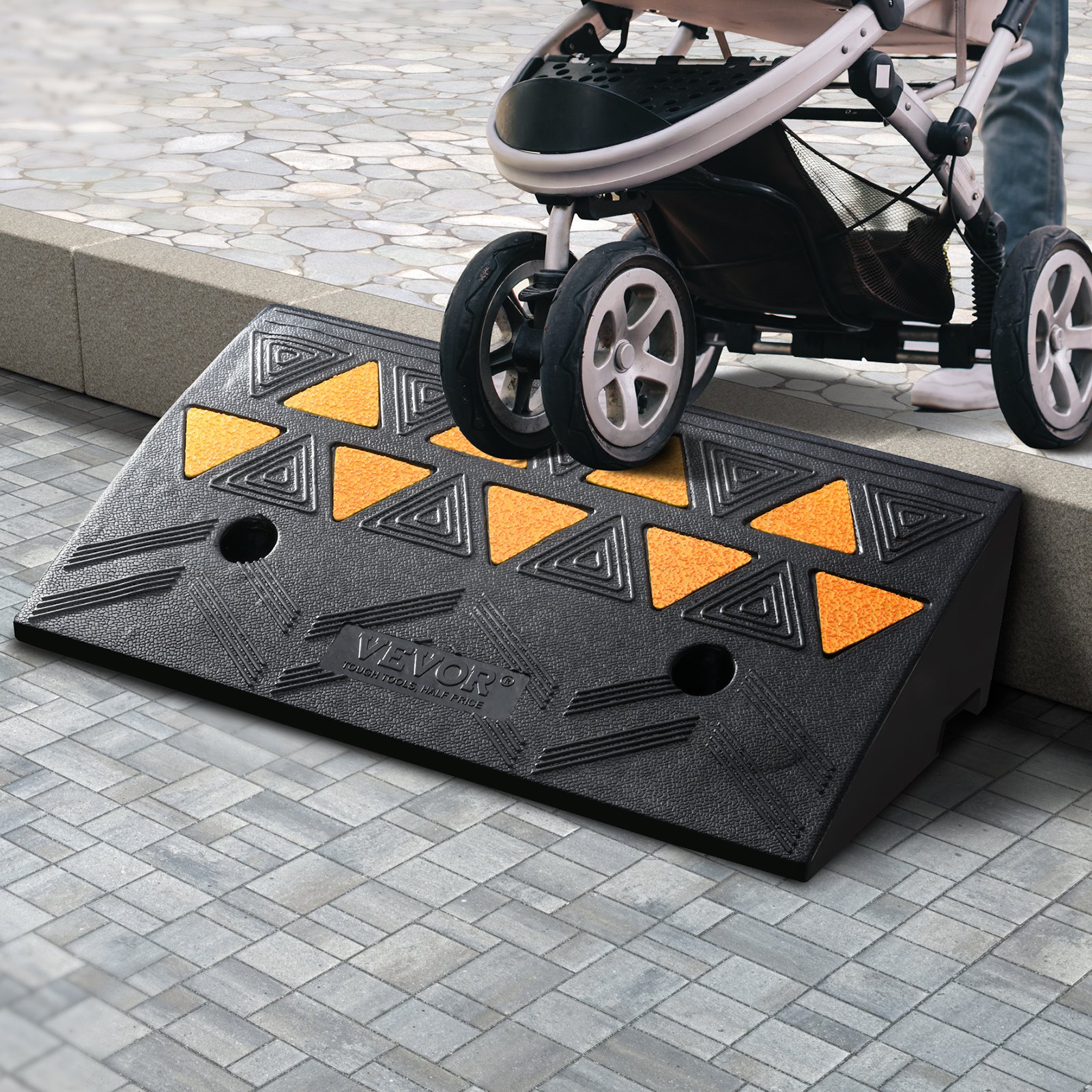 black VEVOR rubber curb ramp with stroller, textured triangular patterns, yellow accents on gray pavement.