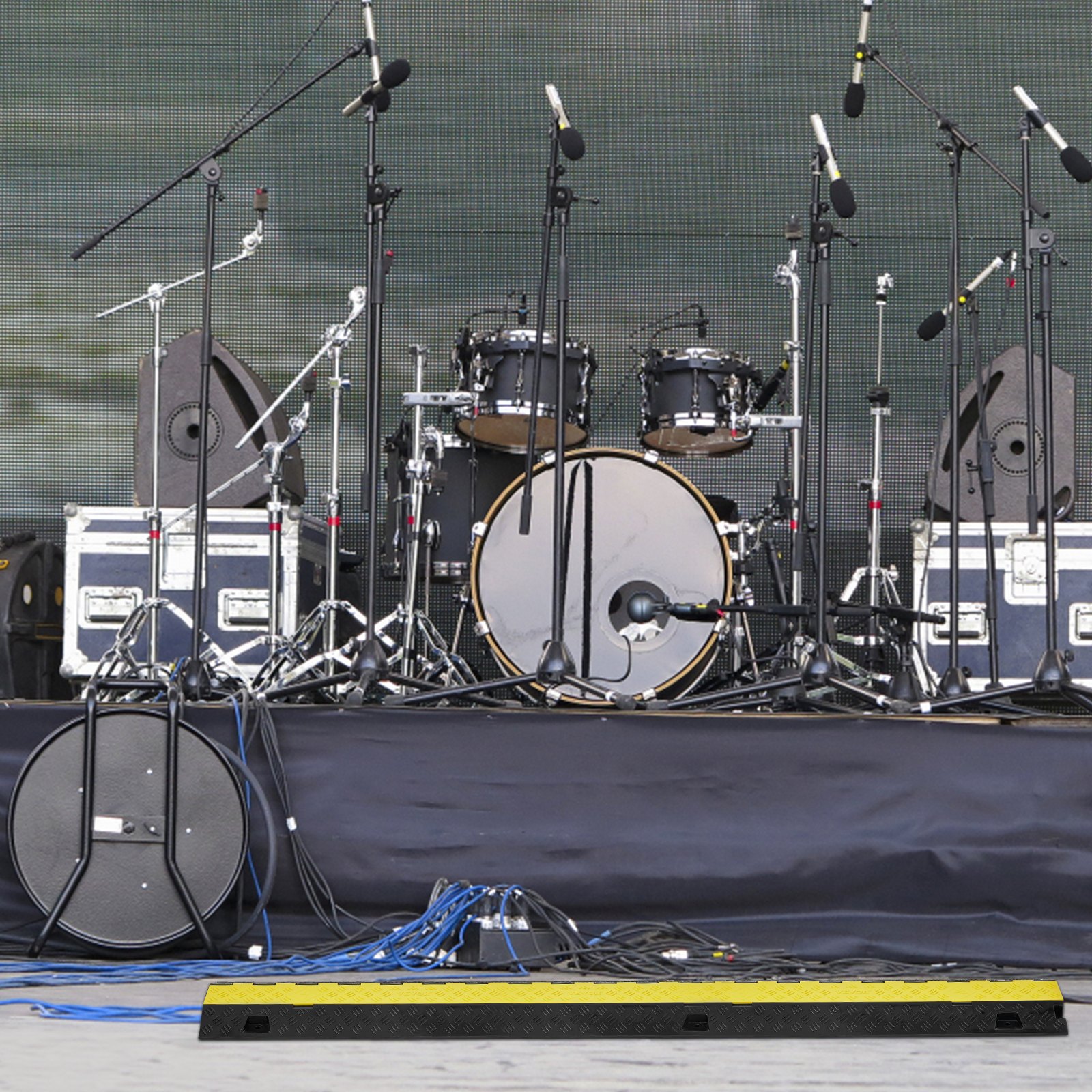 concert stage with drums, microphone stands, audio equipment, and VEVOR cable protector ramp.