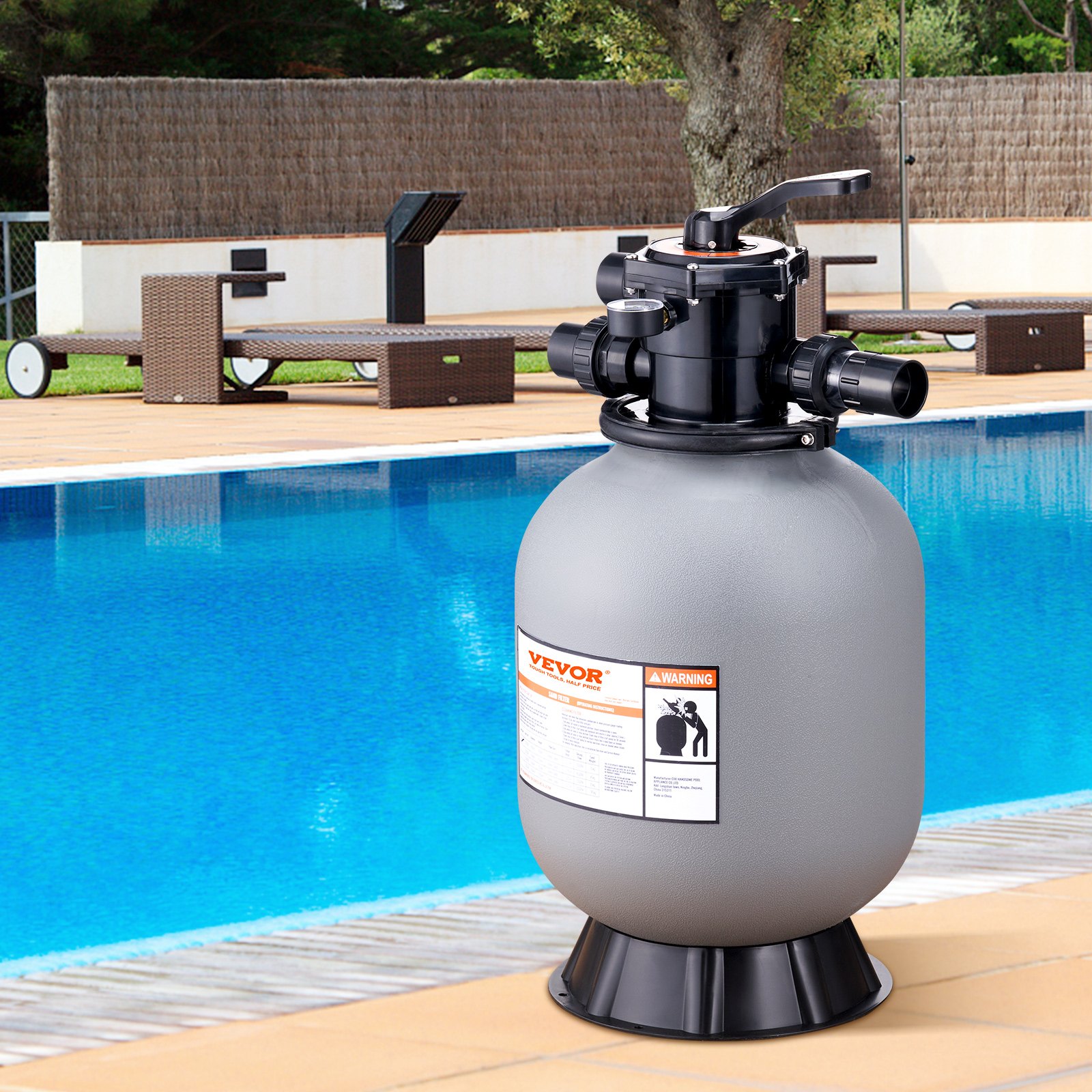 VEVOR sand filter system beside a clear blue pool with outdoor furniture in the background.