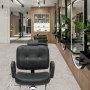 black VEVOR salon chair in a modern salon with wood panel decor and large circular mirrors.