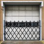 VEVOR security gate in front of a garage door on a brick building.
