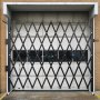 VEVOR folding security gate installed in a garage doorway, fully extended.