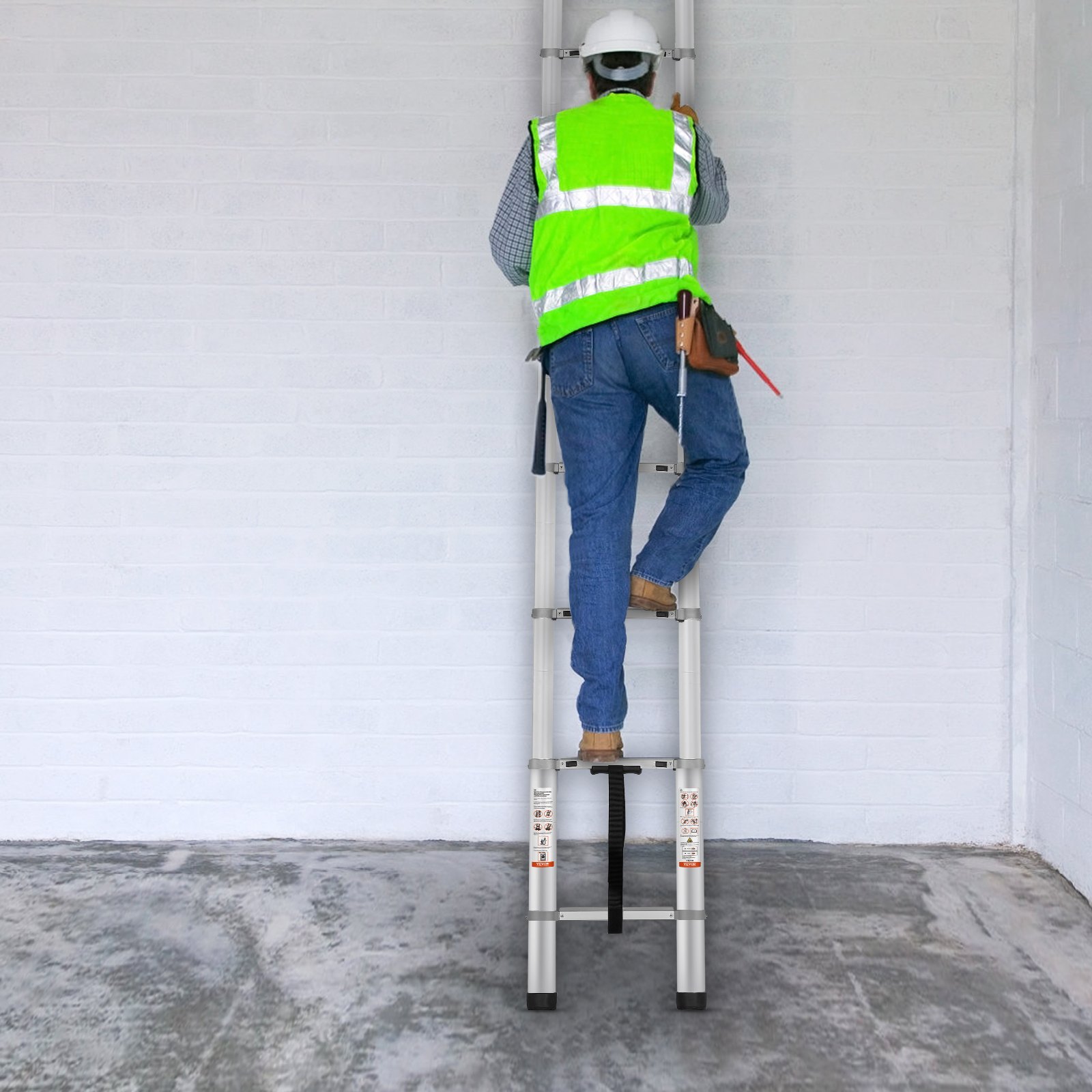 worker in safety gear climbs a VEVOR telescoping ladder against a white brick wall.