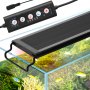 Lampe d'aquarium VEVOR avec réglages réglables et télécommande, illuminant un aquarium vibrant.