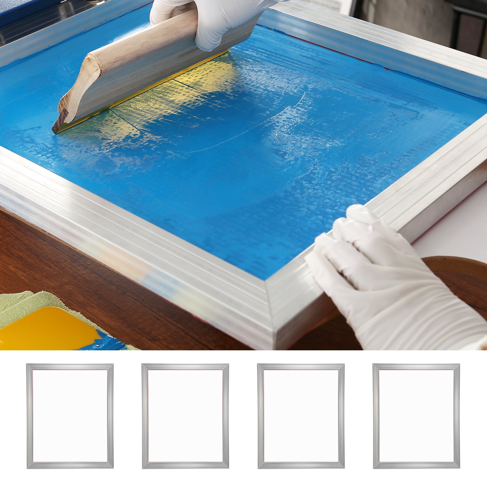 person using the VEVOR screen printing kit with a wooden squeegee on a blue screen, four blank screens aligned.