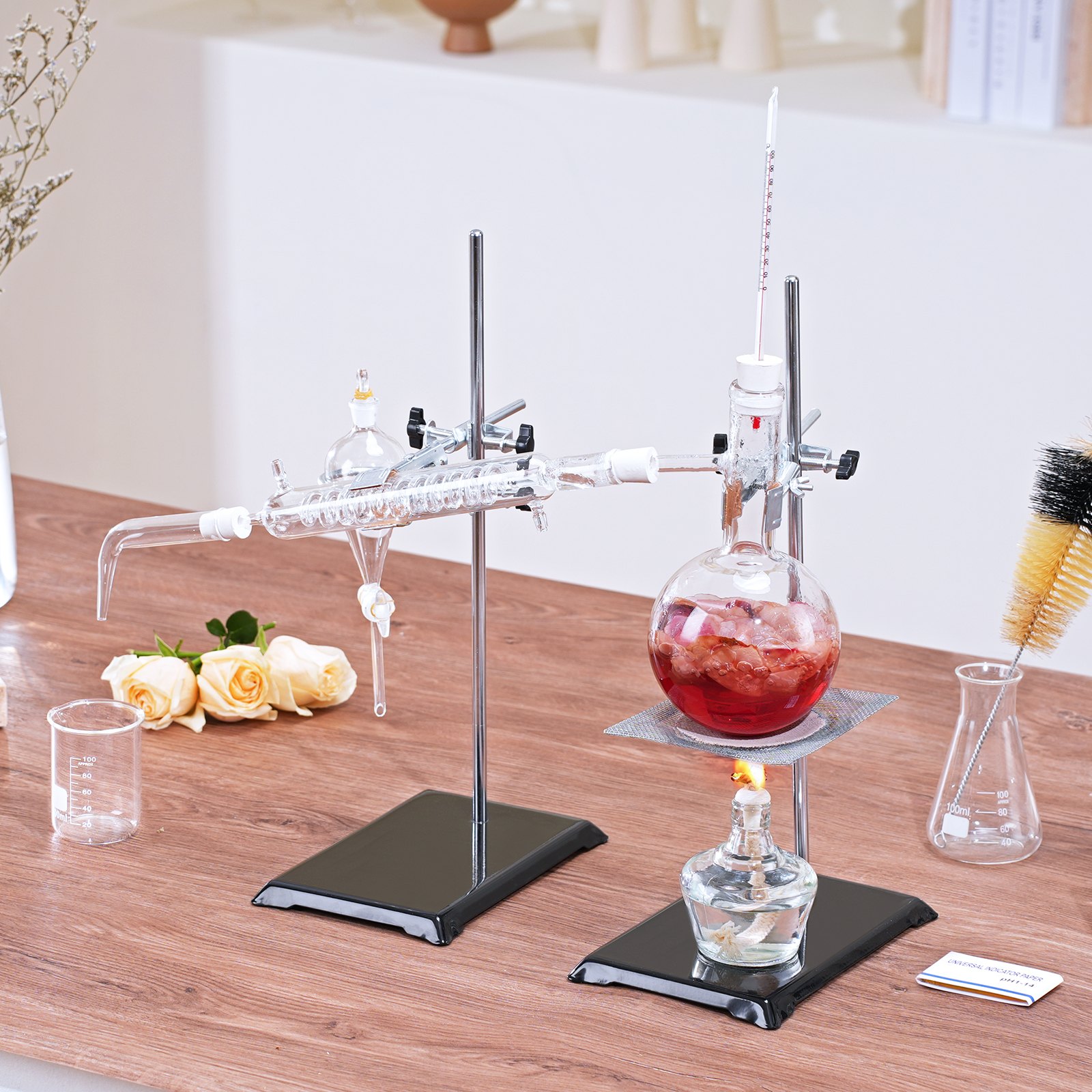 VEVOR essential oil distillation kit shown on a wooden table with glassware and flowers nearby.