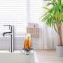 chrome faucet with VEVOR glass rinser in a modern kitchen setting, near a potted plant and books.