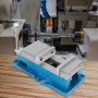 VEVOR cnc vise on wooden table with a lathe machine in the background.
