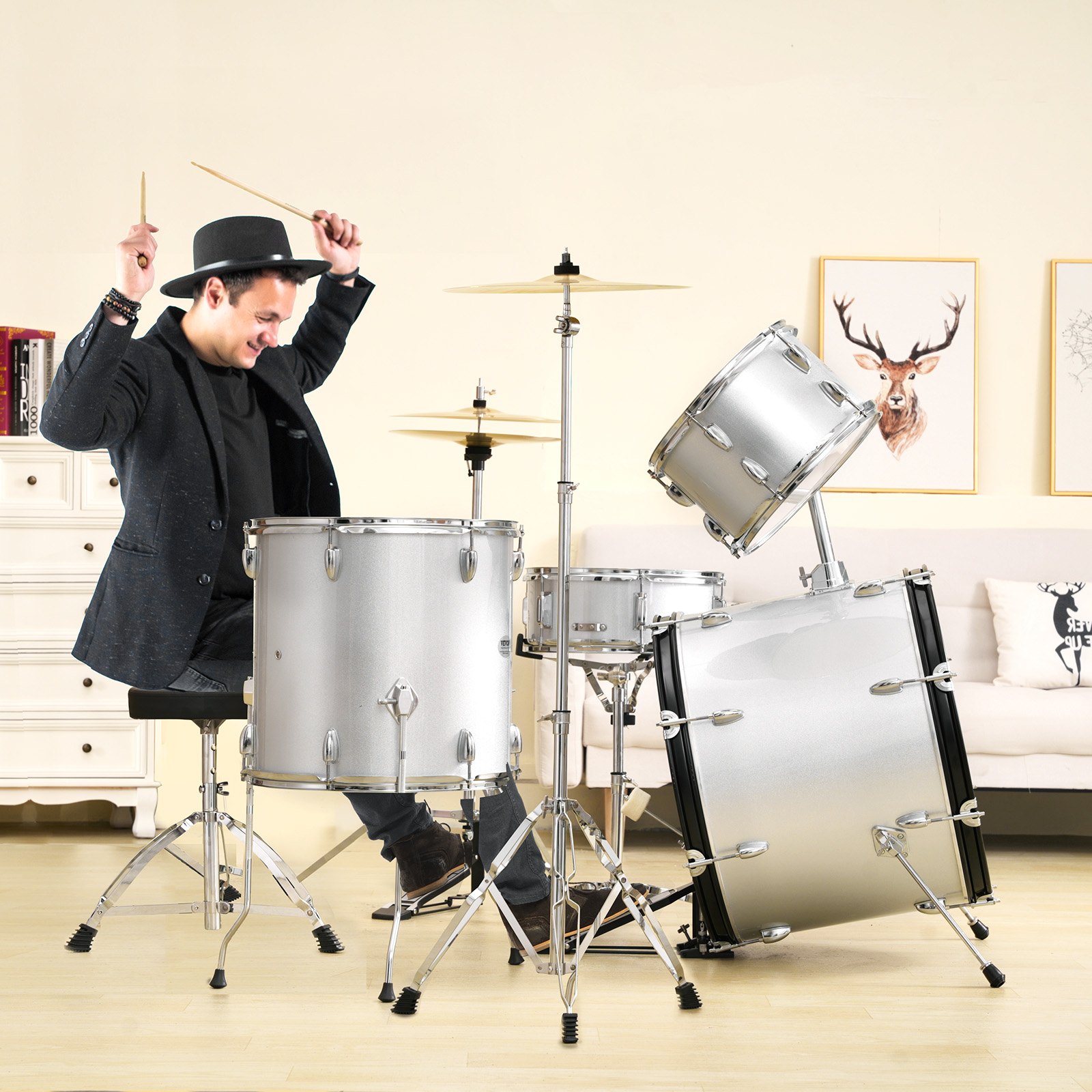 man playing a VEVOR adult drum set in a cozy living room with art on the walls.