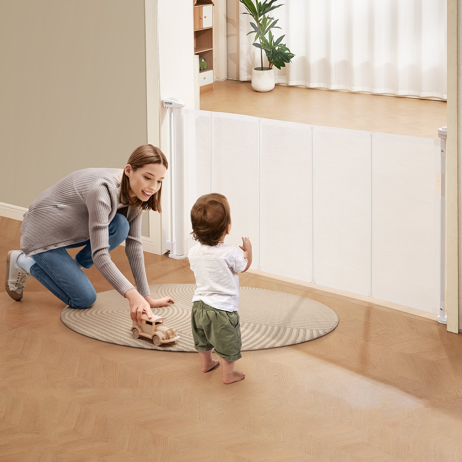woman playing with a child by a VEVOR retractable baby gate in a cozy living room.