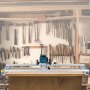 VEVOR router sled on a workbench in a workshop, tools hanging on wall behind.