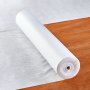 roll of VEVOR carpet protection film on a wooden floor extending onto a white sheet.