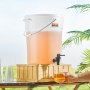 VEVOR beverage dispenser with lemonade, on a wooden stand outdoors, with glasses and hand pouring drink.