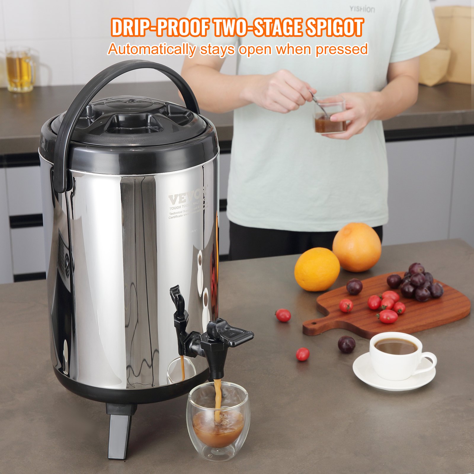 VEVOR beverage dispenser with drip-proof spigot, fruit, and cup of coffee on a kitchen counter.