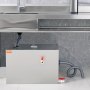 VEVOR grease trap installed under a stainless steel kitchen sink with gray tiled wall background.