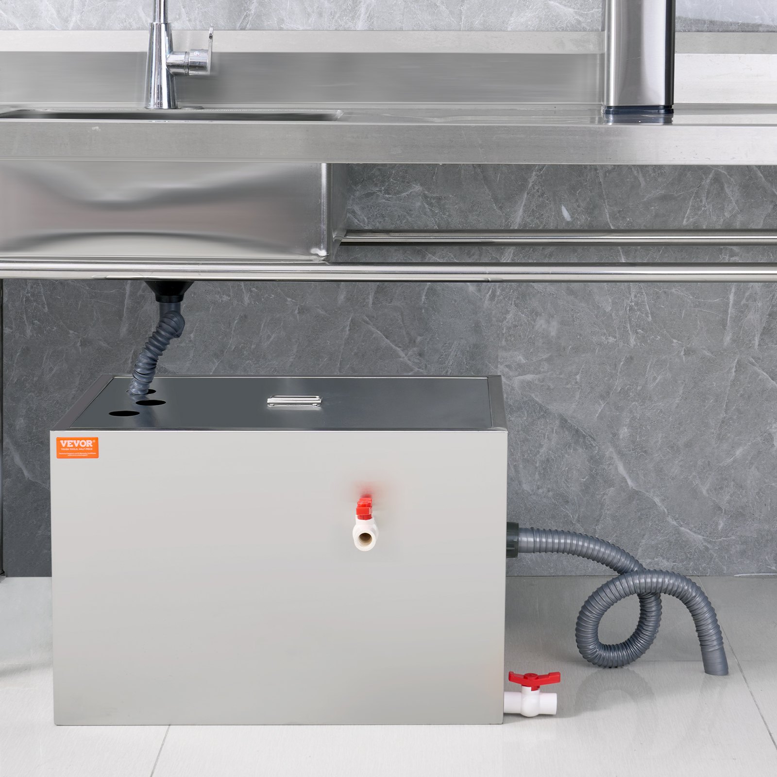 VEVOR grease trap installed under a stainless steel kitchen sink with gray tiled wall background.