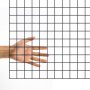 hand behind black VEVOR hardware cloth grid against white backdrop.