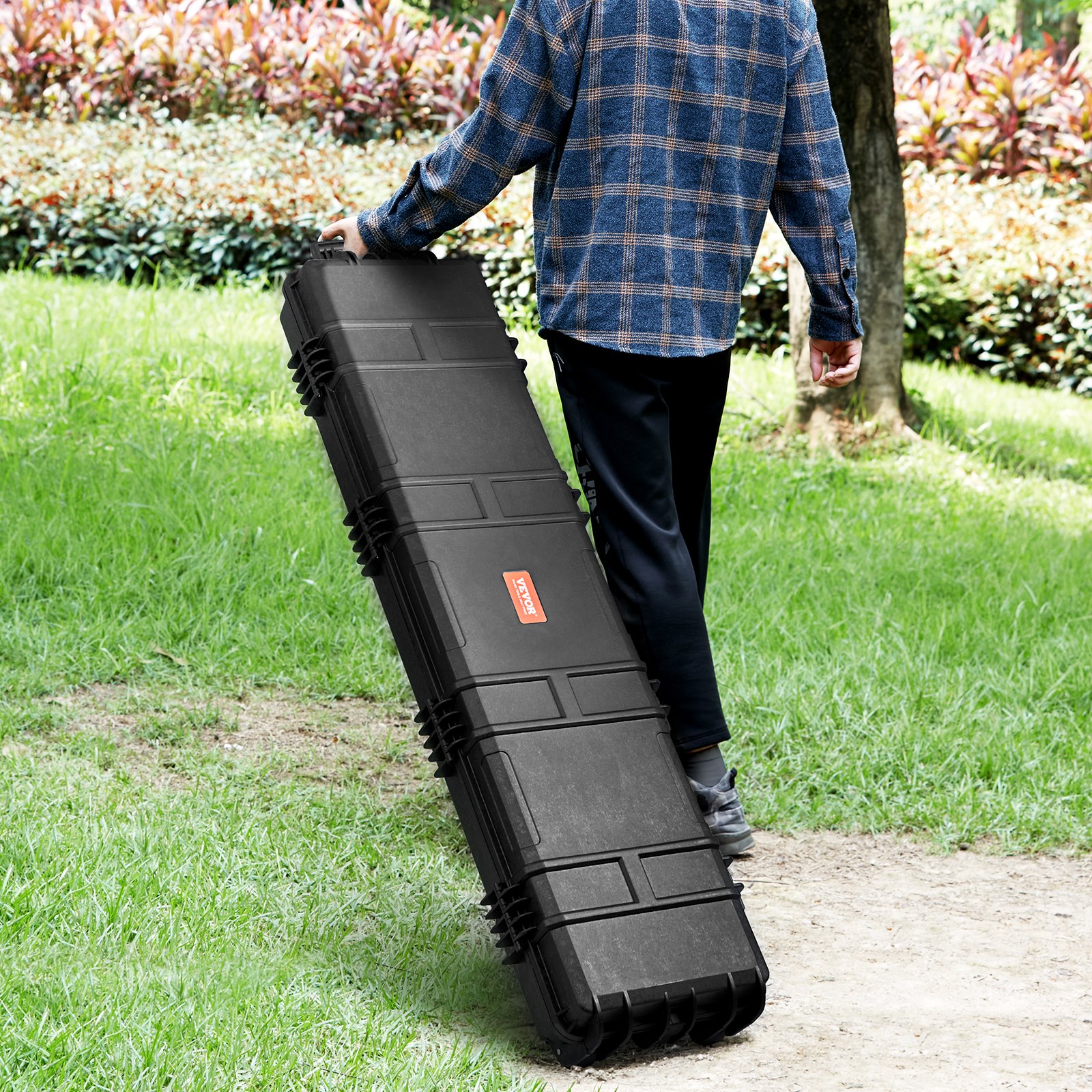 person carrying VEVOR tactical range case in a green outdoor park setting.