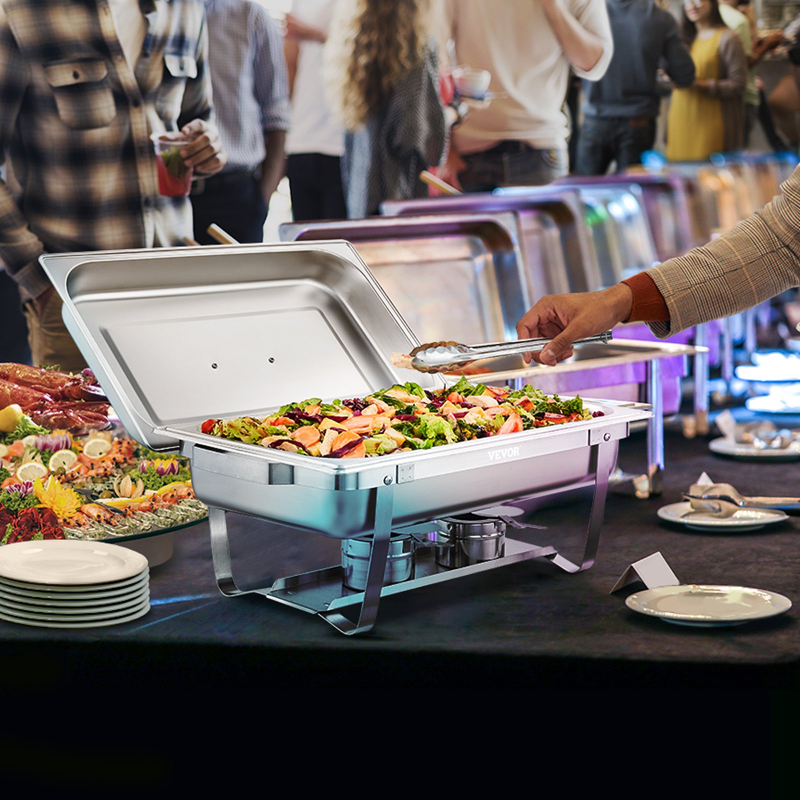 buffet with VEVOR chafing dish set holding fresh salad, surrounded by plates and diverse food options.