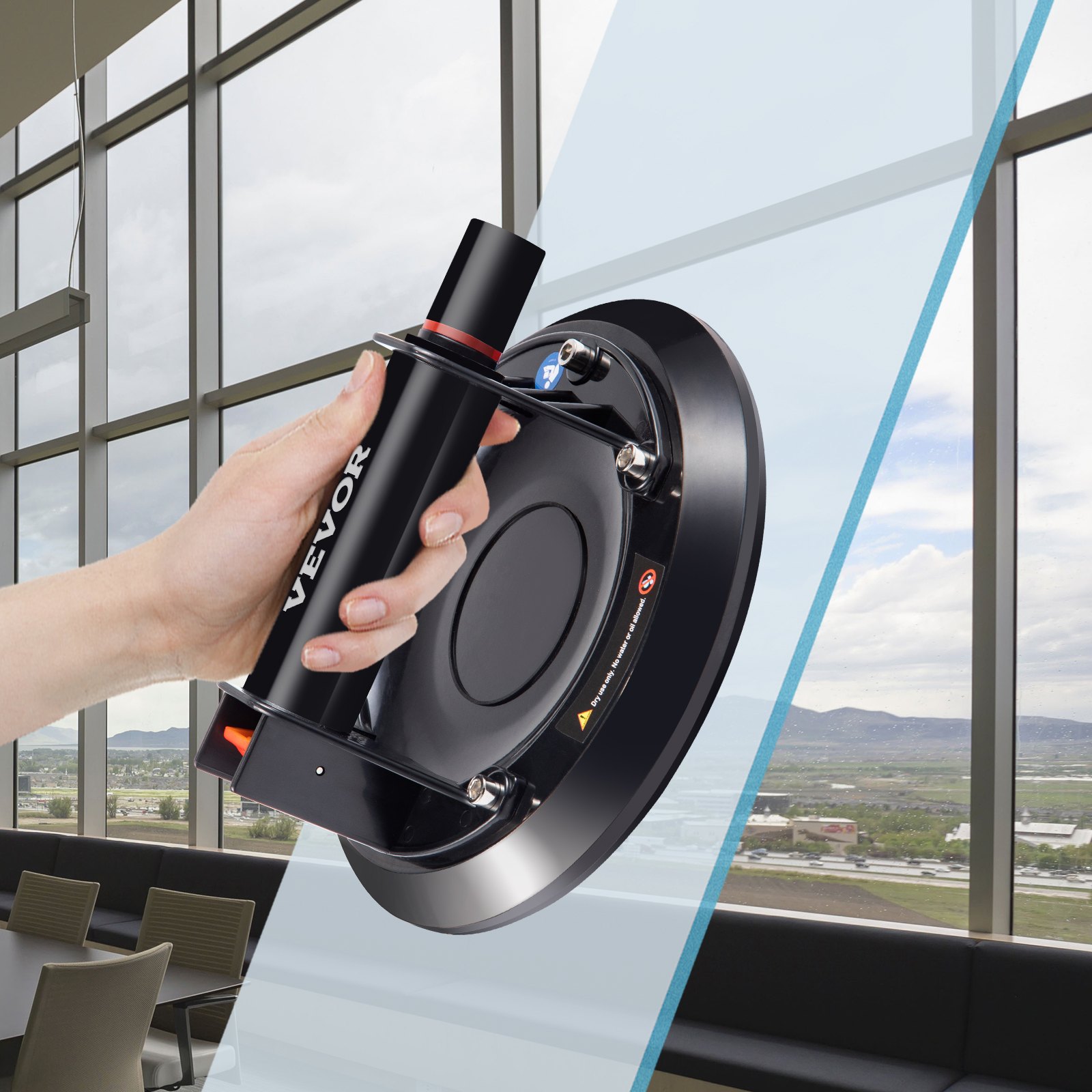 hand holding VEVOR glass lifting suction cup affixed to large window in office space