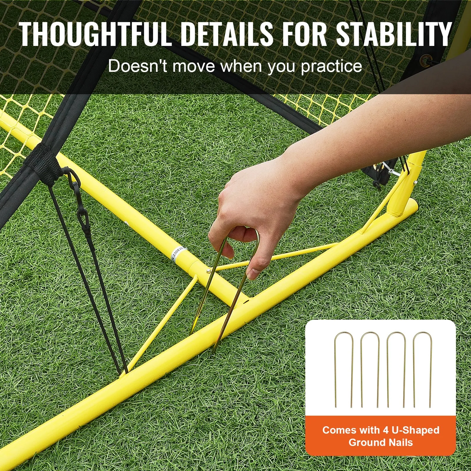 hand securing a yellow VEVOR soccer rebounder frame with u-shaped ground nails on green grass.