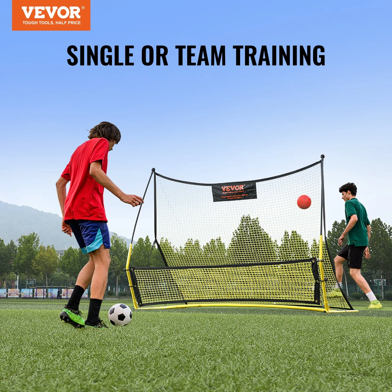 players training with a VEVOR soccer rebounder on a grassy field, with trees and hills in the background.