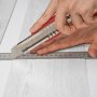 cutting VEVOR vinyl floor tiles with precision using a utility knife and ruler.