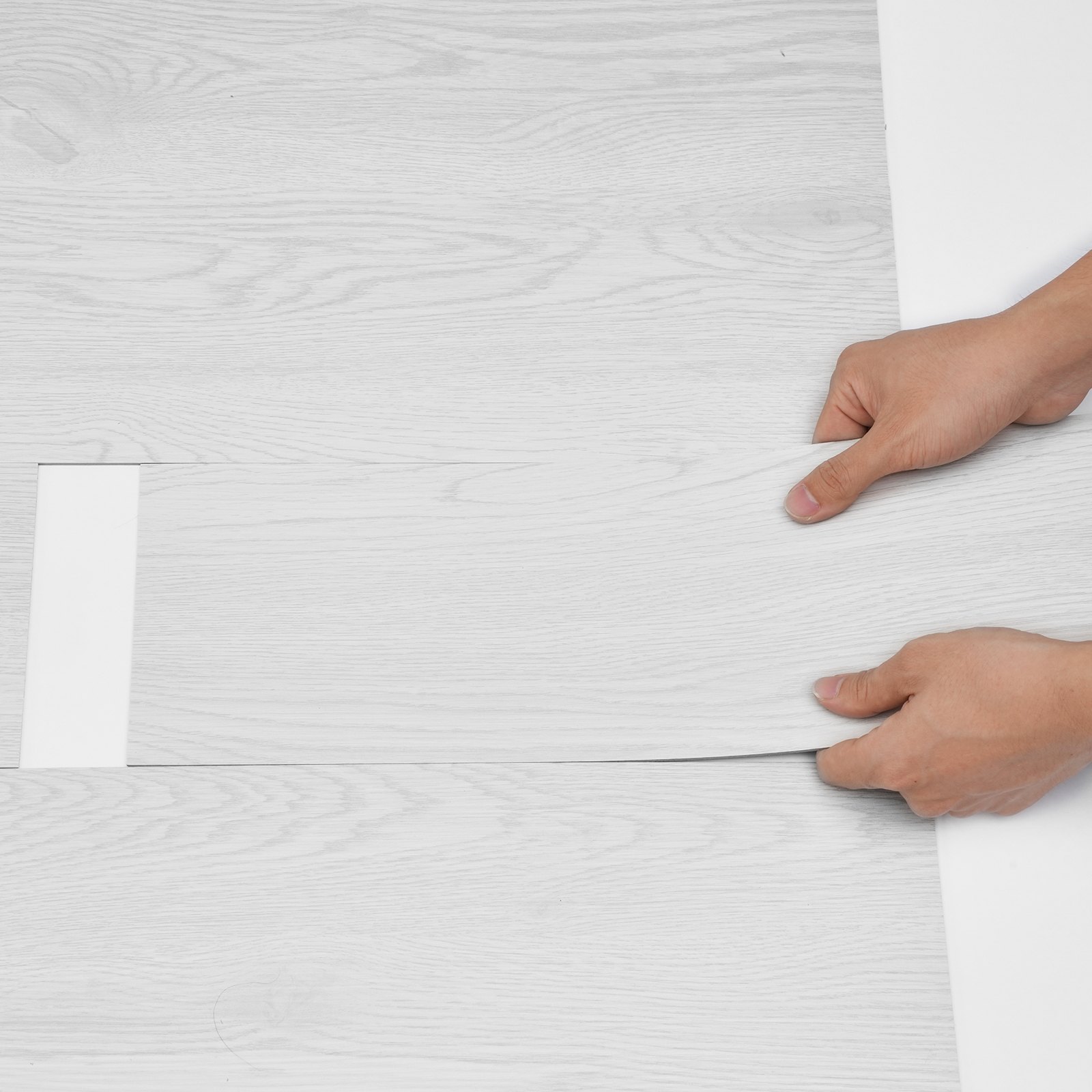 installing light wood-grain VEVOR vinyl floor tiles with hands adjusting the alignment.
